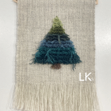 Luonnonvalkealla kudotulla pohjakankaalla ryijynukalla tehty kuusi. Alhaalla vinot suorat hapsut.